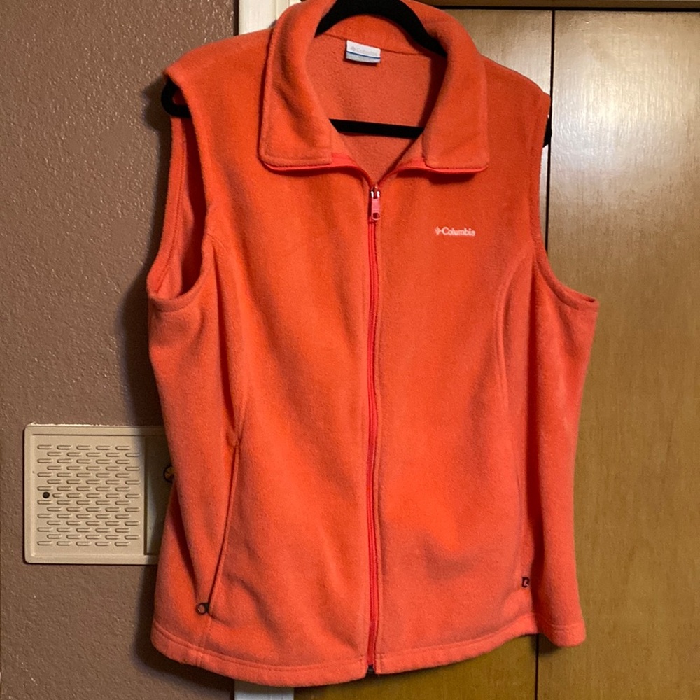 Coral colored  vest. Has front zipper and two front pockets with zippers.
